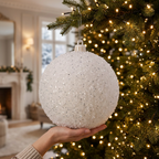 Bambalina nevada blanca de 30 cm con una mano como referencia de tamaño